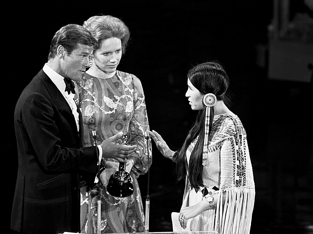 1973’teki törene Brando adına katılan Apaçi yerlisi aktris Sacheen Littlefeather, Roger Moore’un uzattığı Oscar heykelciğini kabul etmeyip konuşmaya başladı.